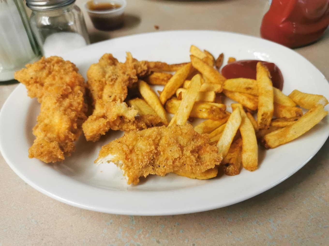 Crispy hand-breaded chicken fingers with fries