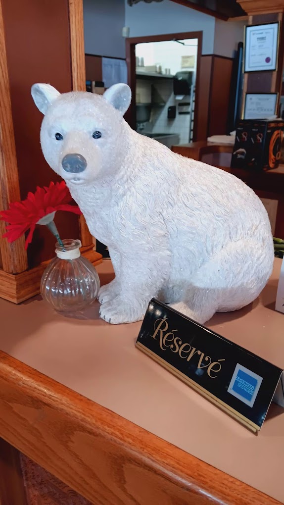 A friendly bear figurine welcoming guests at the host stand